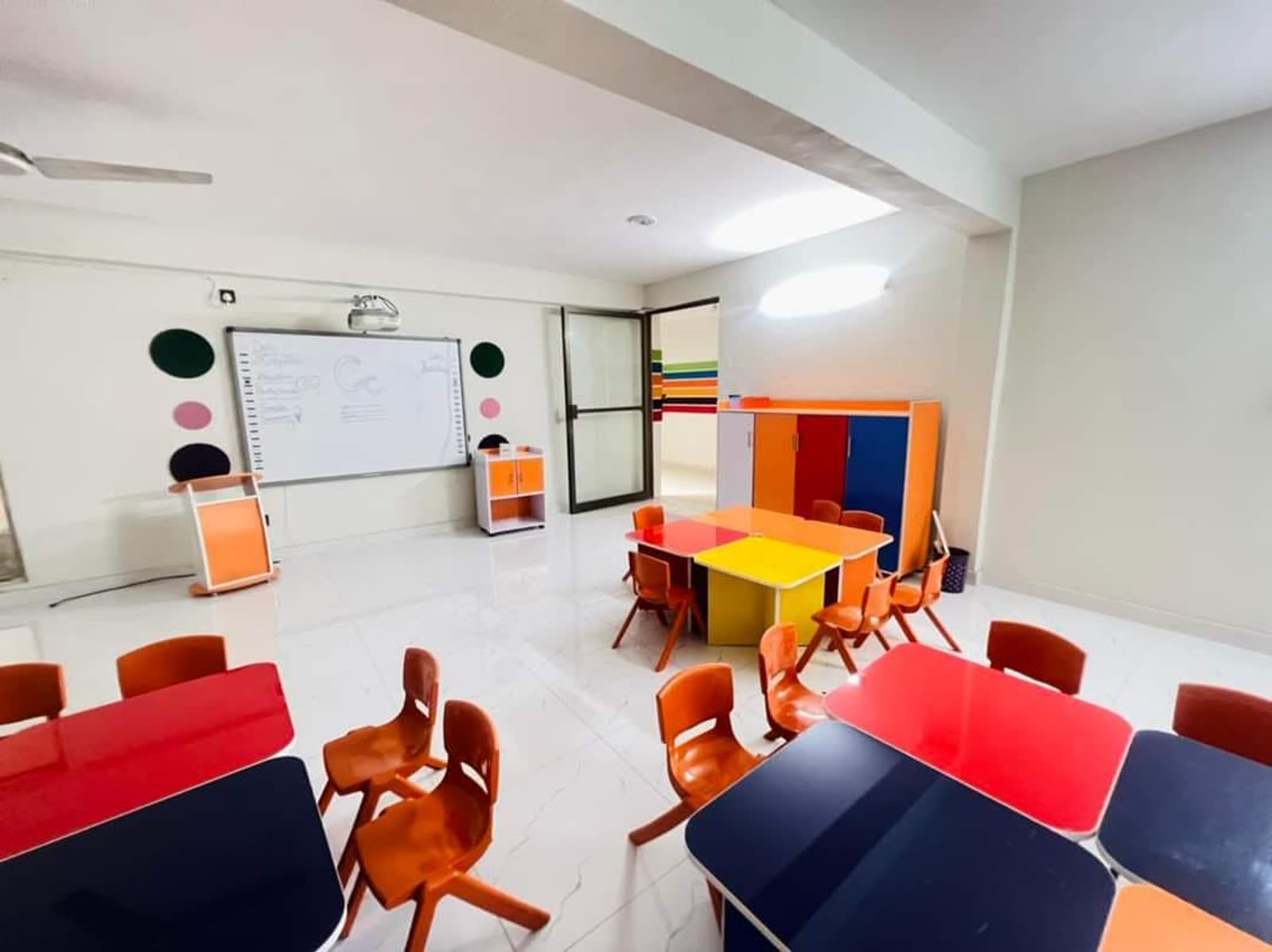 Smart classroom with projector and group tables at Quaid Campus