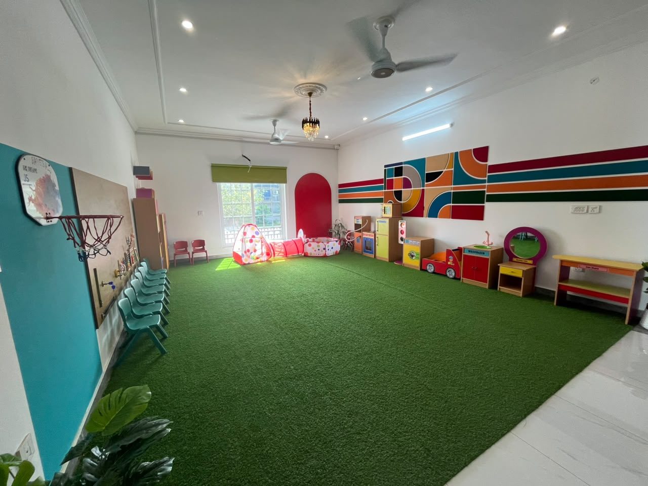 Indoor turf play area with basketball hoop at B-17 Campus