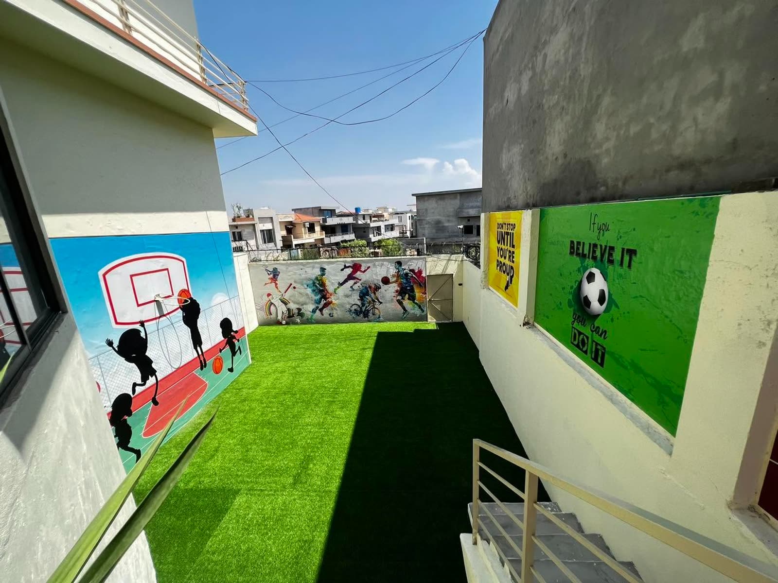Rooftop artificial-turf sports court with murals at Soan Garden Campus